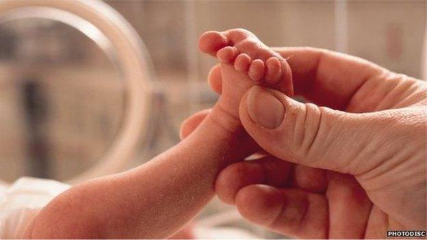 Hand holding a baby's foot