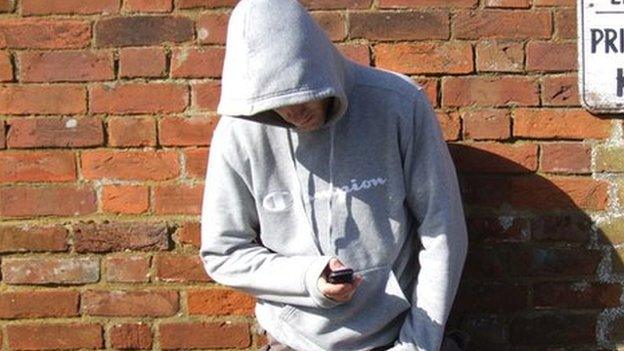 Man in a hoody using a mobile phone