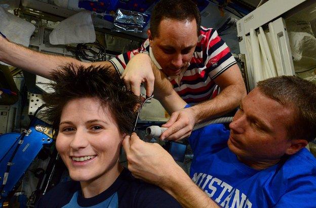 Cristoforetti getting her hair cut with the help of the crew