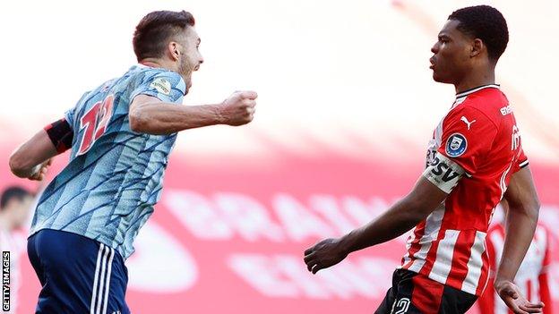 Dusan Tadic of Ajax celebrates his equaliser in front of Denzel Dumfries