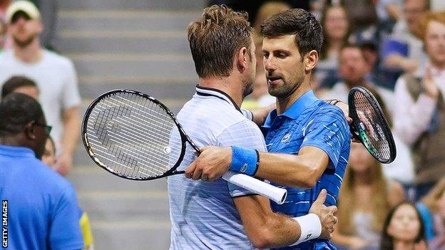 Novak Djokovic and Stan Wawrinka embrace at the net after the former's withdrawal injured