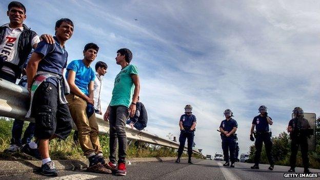 French riot police stand on a road to prevent migrants from reaching the road leading to the ferry port in Calais