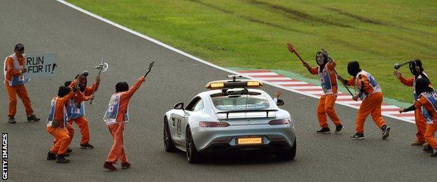 Marshals wearing masks threatening the safety car