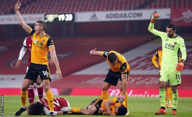 Conor Coady gestures for help after Raul Jimenez is injured