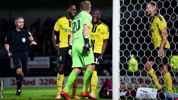 Burton players celebrates as Albert Adomah of Aston Villa penalty is saved by Harry Campbell