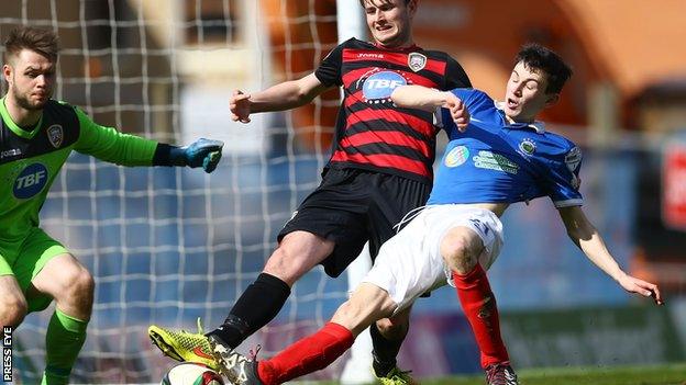 Coleraine's Adam Mullan is challenged by Stephen Fallon during his loan spell at Linfield