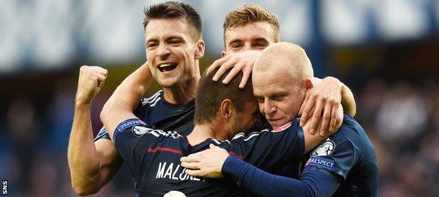 Russell Martin and Steven Naismith congratulate Shaun Maloney on scoring against Georgia in 2014