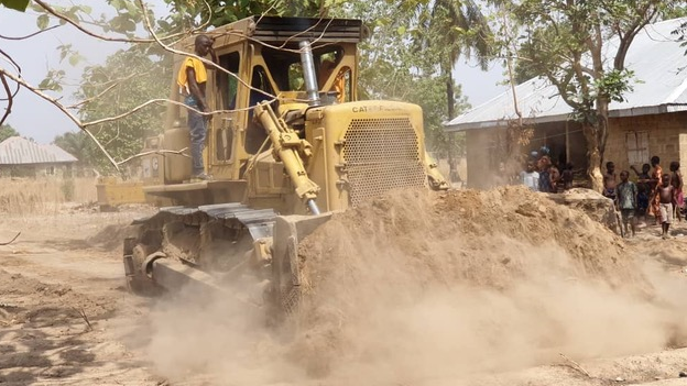 A bulldozer helping build a road financed by Nigeria's Moses Simon in his home village of Obagaji Agatu