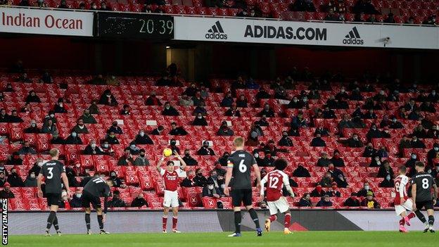 Socially distanced fans at Emirates Stadium watch Arsenal against Burnley