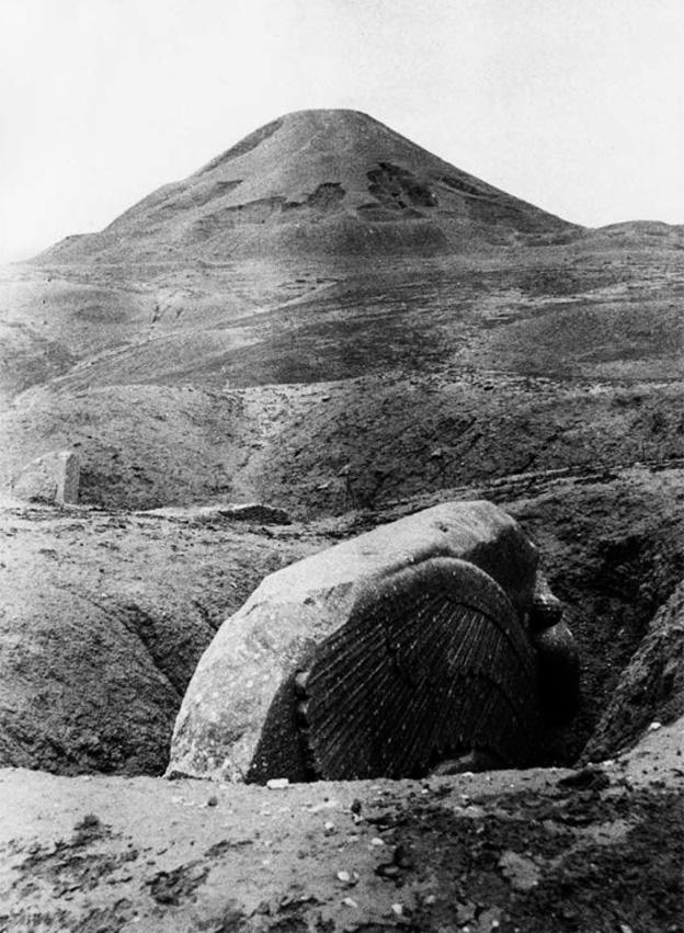 A Lamassu sculpture protruding from the ground