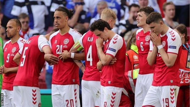 The Danish players protect Christian Eriksen