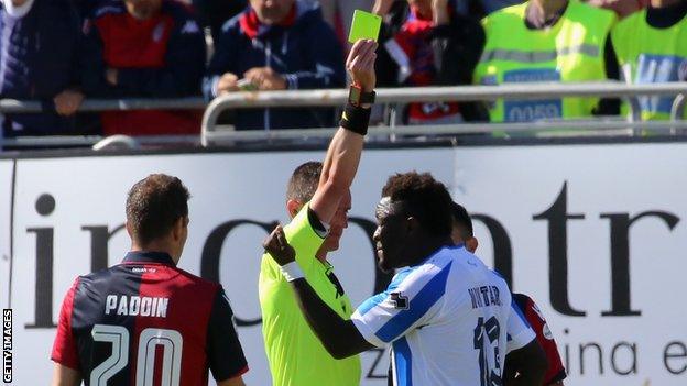 Sulley Muntari is shown a yellow card after he protested against racial abuse