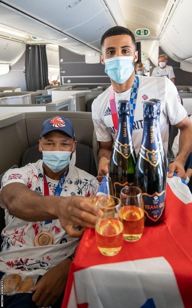 Boxers share drink on flight home from Tokyo 2020.