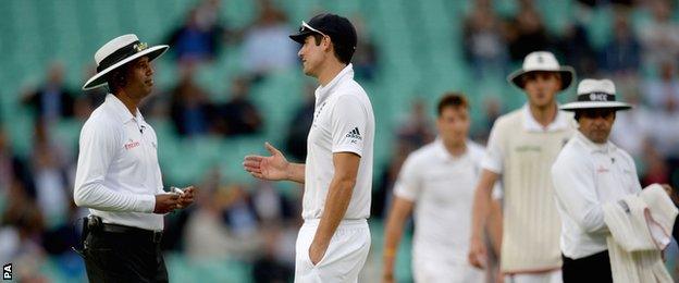 England captain Alastair Cook speaks with the umpires