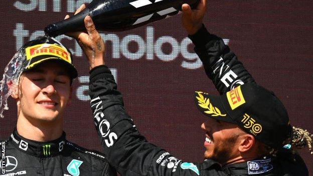 George Russell and Lewis Hamilton celebrate on the podium after the French Grand Prix