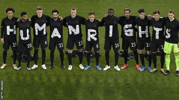 Germany's starting side link arms while wearing black t-shirts, each with a white letter on them, spelling out 'Human rights' before their 2022 World Cup qualifier against Iceland to show support for migrant workers building stadiums in Qatar