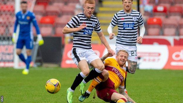 Queen's Park's Liam Brown is tackled by Motherwell's Robbie Crawford