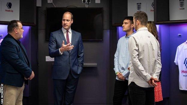 Members of the FC Not Alone club talk with the Duke of Cambridge