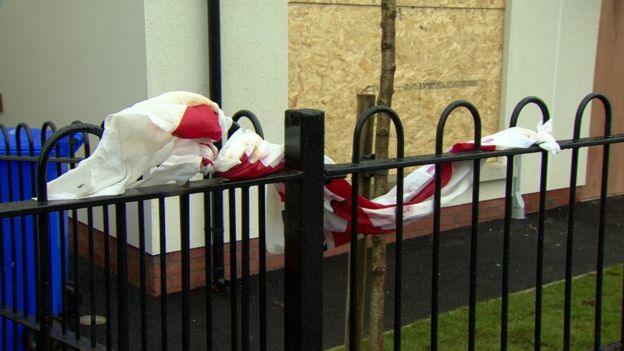 The fence of a house draped in a flag