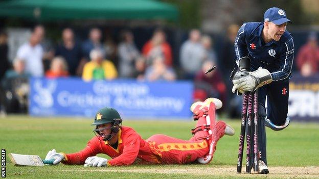 Zimbabwe's Sean Williams makes it home despite the best efforts of Scotland's Matthew Cross