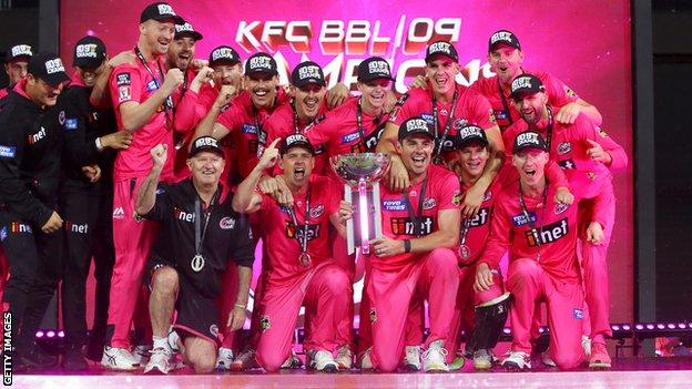 Sydney Sixers players and staff celebrate with the trophy after beating Melbourne Stars in the Big Bash final