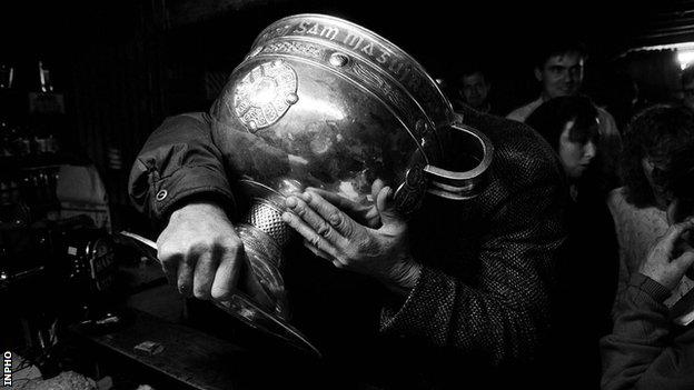 A Donegal fan drinks from the Sam Maguire Cup