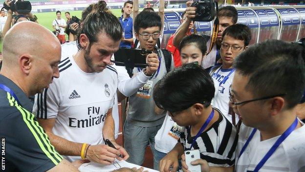 Gareth Bale signs shirts for fans during a Real Madrid tour of China in 2015