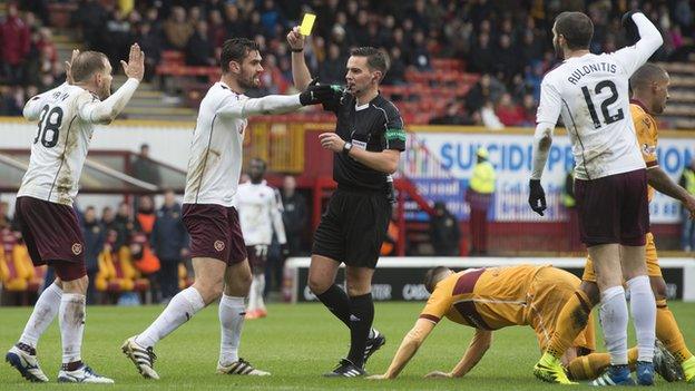 Hearts' Malaury Martin (left) is shown a yellow card from Andrew Dallas