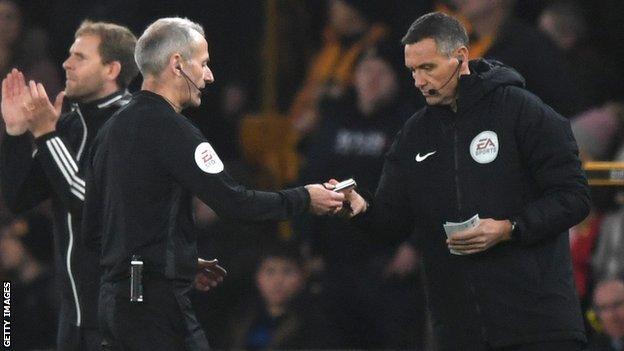 Martin Atkinson consults with Andre Marriner