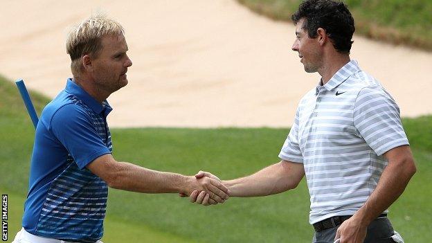 Soren Kjeldsen (L) of Denmark shakes hands with Rory McIlroy