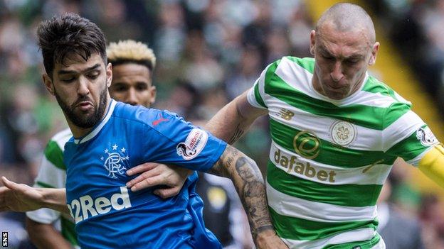 Daniel Candeias of Rangers and Celtic captain Scott Brown vie for posseesion