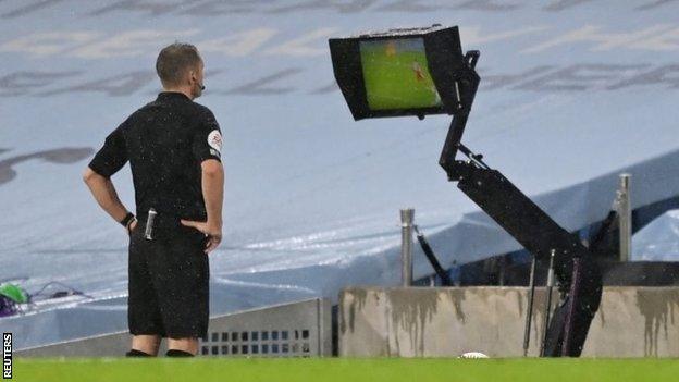 Referee Craig Pawson looks at VAR monitor