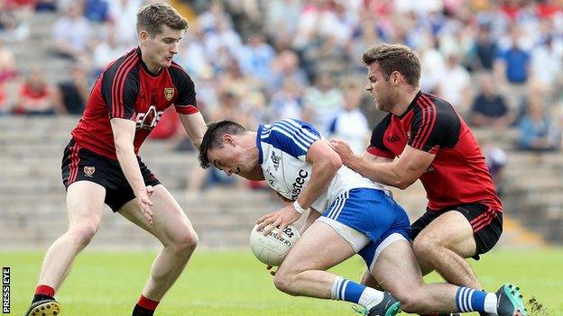 Monaghan's Shane Carey is tackled by Down's Conor Maginn and Gerard Collins