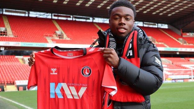 Nile John holds his new Charlton Athletic jersey