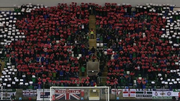 Northern Ireland supporters use cards to create the shape of a poppy