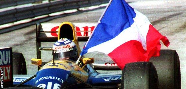 Alain Prost holds his country's flag after clinching his fourth F1 world title at the Portuguese Grand Prix