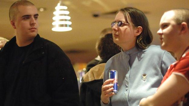 Two men and a woman all on the spectrum share a drink at a social event