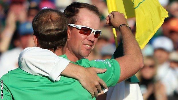 Danny Willett and caddie Jonathan Smart embrace on the 18th green