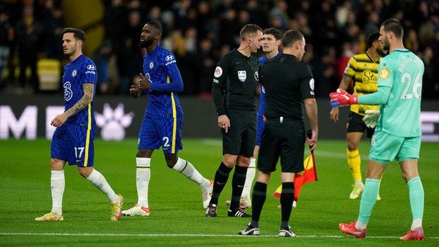 Watford and Chelsea players leave the pitch after the game is stopped because of a medical emergency in the crowd