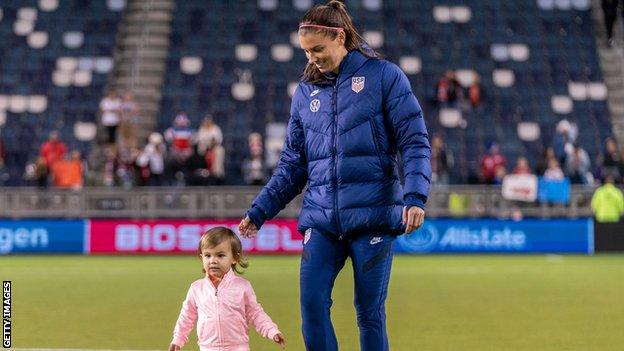 US Women's National Team player Alex Morgan, on the field with her daughter, 2021.