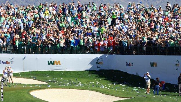 Beer cans and bottles litter the 16th hole at TPC Scottsdale after Sam Ryder's hole-in-one during round three