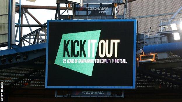 The Kick It Out logo on a screen in a football stadium