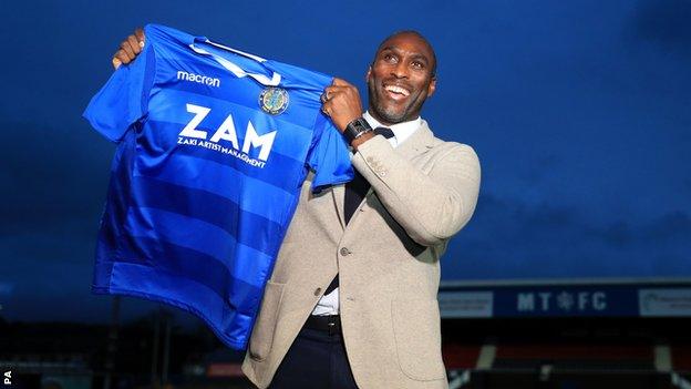 Sol Campbell holds aloft a Macclesfield shirt