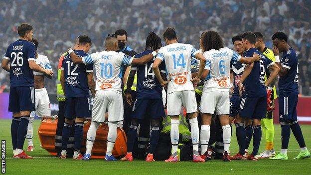 Players forming a wall around the player as he was receiving medical attention