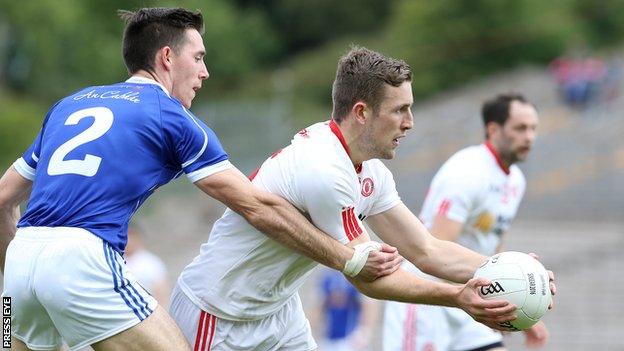 Killian Brady challenges Niall Sludden during the first half of the replay at Clones