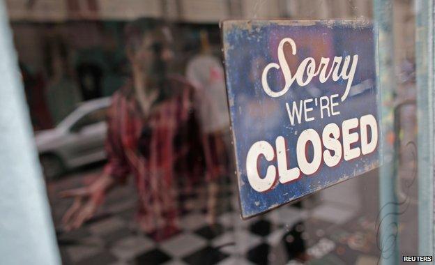 Man walks past "sorry we're closed" sign in Paris