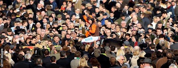 Sam Waley-Cohen on Long Run celebrates amongst race goers after winning the Gold Cup on Long Run at Cheltenham Racecourse