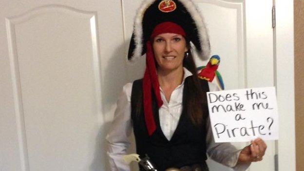 A woman dressed as a pirate with a message reading 'does this make me a pirate?'