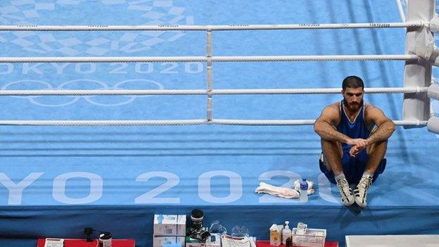 Aliev sits on the ring apron in protest after his defeat