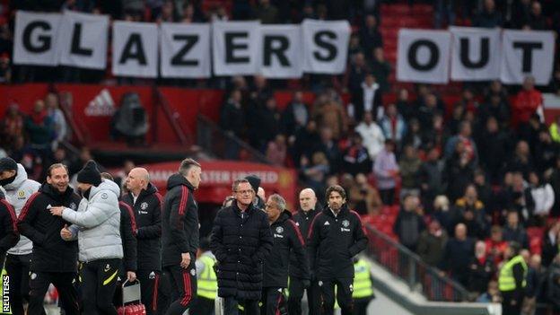 Manchester United fans displaying a 'Glazers Out' banner